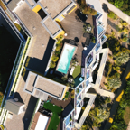 Top view of a modern luxury residential rooftop with terraces and a swimming pool.
