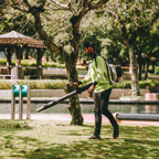 A man using a leaf blower in a vibrant Kuala Lumpur park, showcasing daily outdoor maintenance.