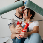 A couple enjoying a moment while painting their home, symbolizing love and teamwork.